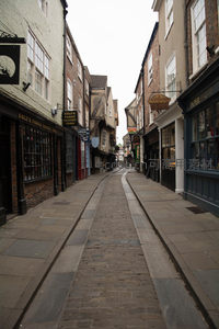 约克古城窄巷石板路，两侧砖墙老店林立，宁静古朴氛围浓厚