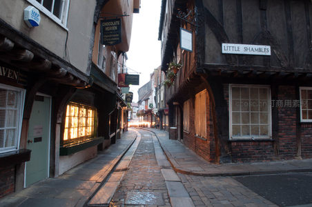 约克小巷黄昏时分，木构房屋林立，暖光窗棂映照鹅卵石路