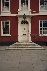 红砖白饰古典建筑入口：典雅门廊与石阶映衬英伦风情