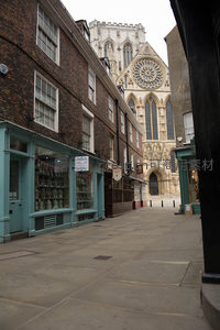 窄巷尽头矗立约克大教堂哥特式玫瑰窗立面