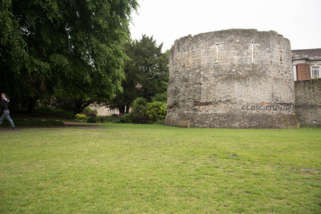 约克城墙博伊尔塔楼圆形石堡与行人掠影的静谧公园景致