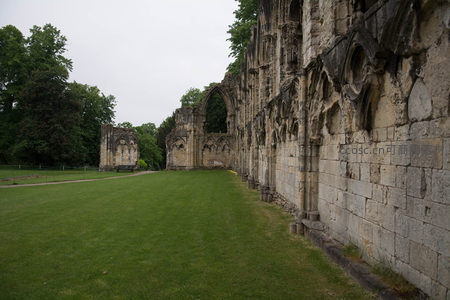 约克修道院长廊遗址：高耸石墙雕花拱券与葱郁林带纵深构图