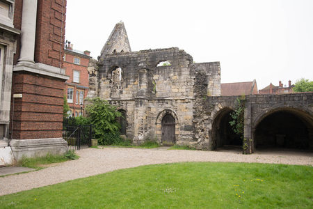 修道院废墟与现代红砖建筑并置，尖顶残垣与规整窗格形成时空对话