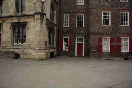 古典石砌建筑转角与红砖房屋相邻，红百叶窗与白窗框构成英伦街景特色