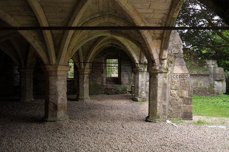 哥特式石柱廊道内部，尖拱交错，光影斑驳，古韵深沉