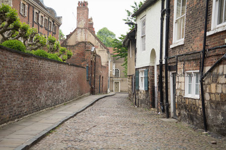 约克古城石板小巷，红砖墙与白墙建筑交错的静谧街景