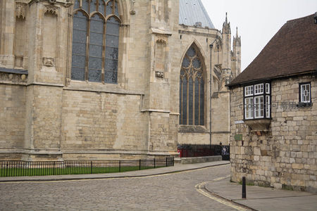 约克大教堂侧翼特写，哥特式彩窗与石雕细节映衬古朴街角