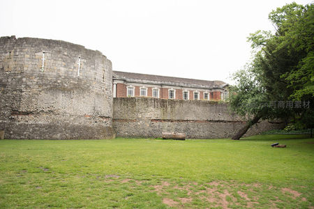 约克古城墙圆形塔楼与红砖建筑并立，草坪开阔绿意盎然