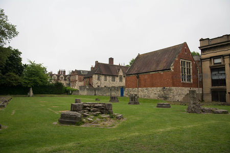 中世纪修道院遗址庭院遗存石基，红砖教堂与现代建筑环绕