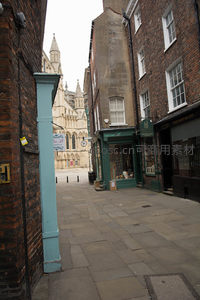 约克大教堂尖塔在狭窄巷道尽头若隐若现的古典街景