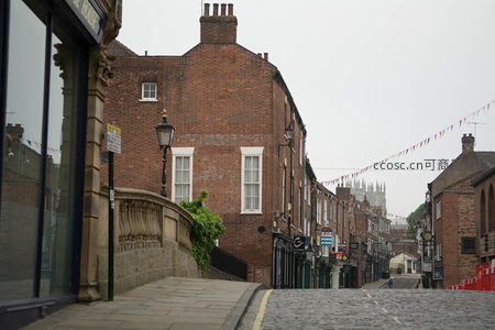约克古城石板街景，红砖建筑与彩旗点缀宁静晨光