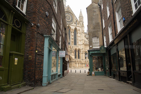 约克古城窄巷尽头的宏伟教堂玫瑰窗与彩绘玻璃