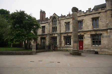 圣威廉学院外广场：古朴砂岩建筑群与独立石柱的对称构图