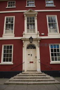鲜红外墙配奶油白装饰的乔治亚风格建筑，典雅门廊与石阶彰显英伦古典韵味