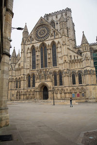 约克大教堂宏伟西立面，哥特式玫瑰窗与尖塔耸立，游客仰望庄严圣殿