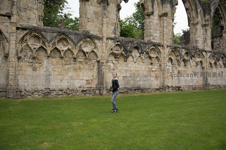 游客漫步约克修道院遗址绿茵草地，古老拱券石墙诉说历史沧桑