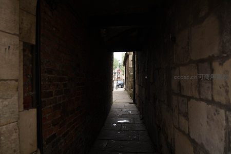 幽深砖石巷道尽头透出微光，青石板路映水洼倒影