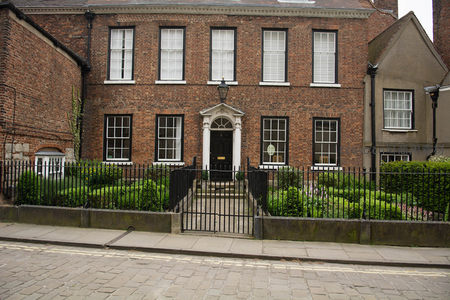 红砖乔治亚风格联排住宅，白窗黑框配古典门廊与铁艺围栏