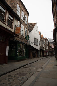 约克肉铺街鹅卵石窄巷，彩色店铺林立，悬挂牌匾诉说百年商史