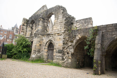 古老修道院残垣拱门特写，藤蔓攀爬石壁显岁月痕迹