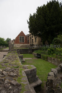 罗马城墙遗址与维多利亚建筑并置，绿茵小径穿行其间