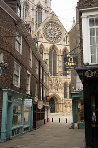 约克大教堂玫瑰窗与古街巷景致，砖石建筑映衬历史厚重感