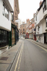 约克古城窄巷清晨静谧街景，白墙砖房与远处教堂尖顶相映成趣