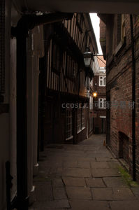 幽深古巷光影交错，木质结构老屋与砖墙诉说历史沧桑