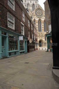 窄巷尽头约克大教堂玫瑰窗与尖塔，砖墙店铺林立古韵悠长
