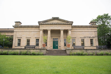 古典主义风格博物馆前庭，绿草坪环绕，双柱门廊配青门与陶盆绿植