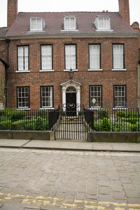 红砖乔治亚风格联排别墅，黑铁栅栏围合精致前院