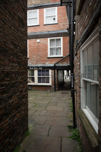 砖墙夹缝中的窄巷，红砖建筑与白色窗框构成经典英伦街景