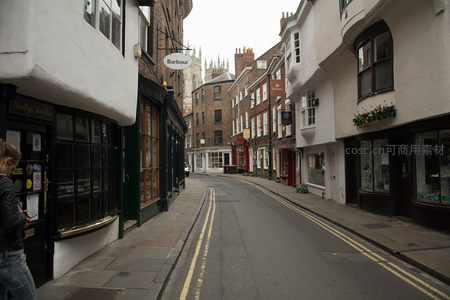 约克老城街角一瞥，白墙店铺与远处教堂尖塔构成经典城市天际线