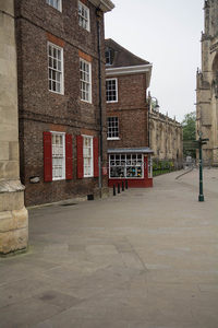 红砖老楼配朱红百叶窗，街角红色小亭售货，大教堂尖塔隐现远处