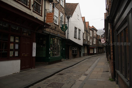 约克老街晨光微照，木质悬挑屋檐与绿漆橱窗相映成趣
