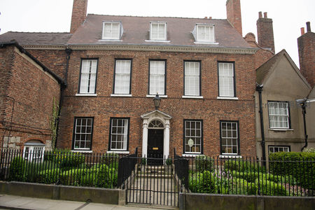 红砖乔治亚风格联排住宅，黑框白窗配古典门廊与铁艺围栏