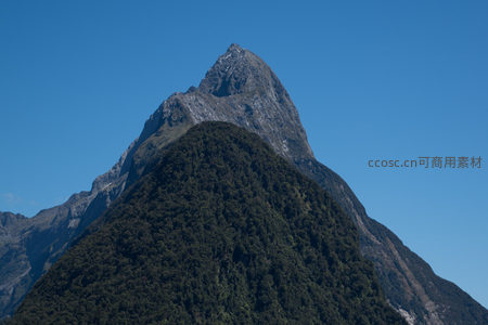 米尔福德峡湾尖峰山峰航拍，蓝天映衬下雄伟峻峭