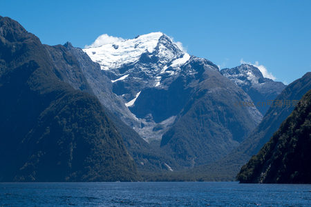 雪冠峰峦环抱深邃峡湾，澄澈湖面倒映苍翠群山