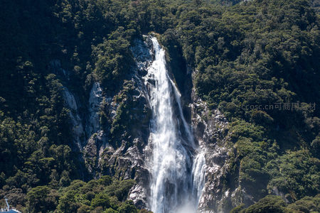 航拍密林中飞流直下的壮观瀑布，水雾弥漫，岩壁陡峭
