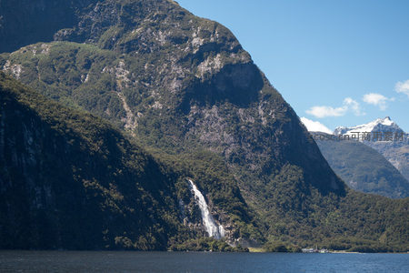 瀑布飞泻入峡湾，青山环抱雪峰映水清幽