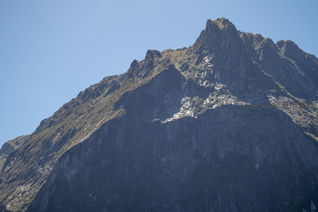 近摄山峰岩壁细节：风化纹理与高山植被共生