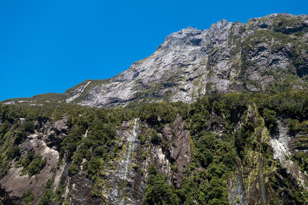晴空下巍峨山脊线蜿蜒起伏，绿茵覆盖险峻峰峦