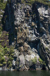 垂直岩壁纹理丰富，光影切割出立体层次的峡湾地质奇观