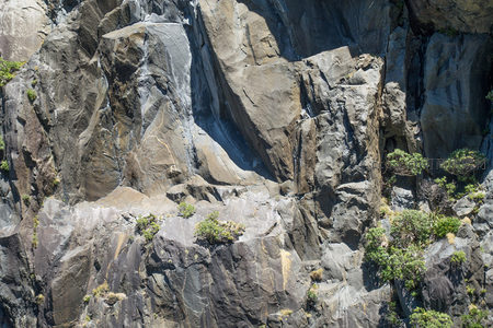 多色岩层交叠的悬崖剖面，矿物脉络如天然水墨画般延展