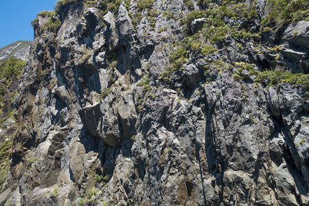 嶙峋山岩层叠起伏，青翠草甸点缀于断崖缝隙之间