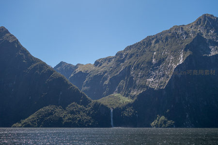 峡湾壮丽全景：碧水映衬巍峨青山，飞瀑垂挂幽谷深处