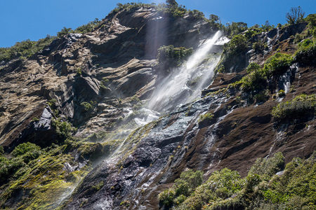 山体斜坡多级瀑布群奔涌而下，水帘交织，光影流动，展现地质变迁与生态共存之美