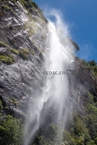 阳光穿透水雾的悬崖瀑布，飞流直下气势磅礴