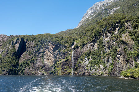 孤瀑悬垂于巍峨山崖之间，碧水荡漾映衬苍翠峰峦与晴空