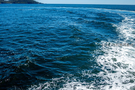 船尾浪花划破深蓝海面延伸至远方
